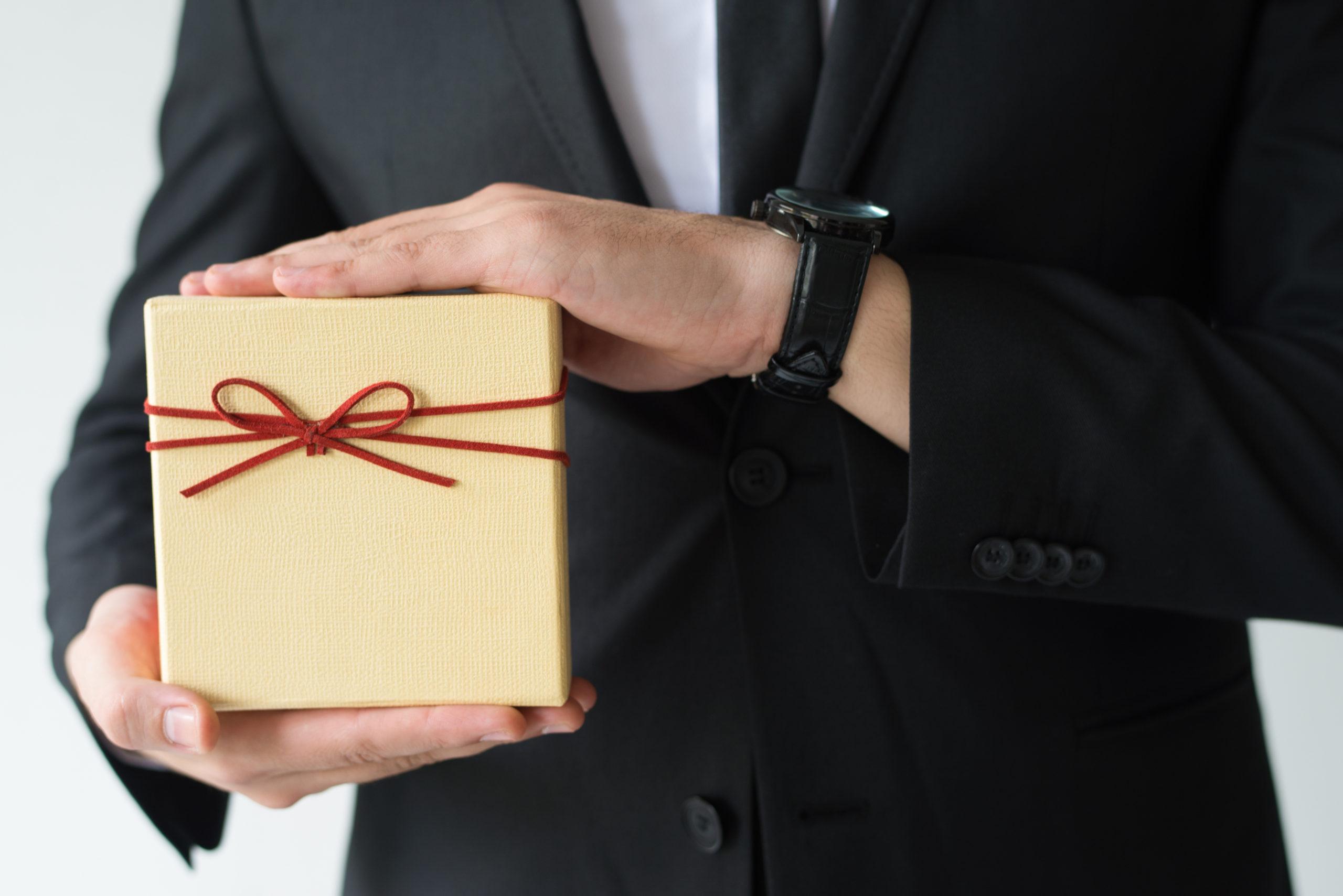 Close-up of man with wristwatch holding gift box Next Best Product Recommendation